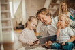 © Geber86 - Family playing and using a tablet in the living room at home