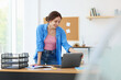 © New Africa - Woman using laptop at wooden desk indoors. Home workplace