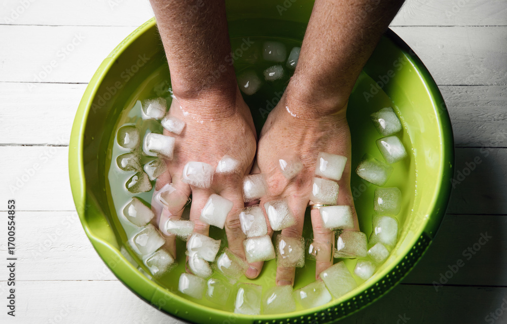 Foto de Stock Man holding hands inside ice water bowl with ice cubes ...