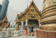 © avtk - Three people (two adults and one child) stand in the foreground with their backs to the camera. They look at the temple with their arms outstretched, creating a sense of admiration and joy.