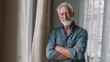 © Johannes - portrait of happy retired senior man standing at home near window satisfied old man looking at camera and smiling while standing near the window positive and confident elderly enjoy his retirement no