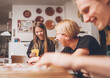 © Soloviova Liudmyla - Cheerfully warm home togetherness cozy scene of family playing cards together in home kitchen. Girls and boys smiling and laughing with moms. Holidays time spending and relations concept image.