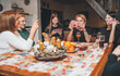 © Soloviova Liudmyla - Cheerfully warm home togetherness cozy scene of family playing cards together in home kitchen. Girls and boys smiling and laughing with moms. Holidays time spending and relations concept image.