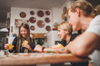 © Soloviova Liudmyla - Cheerfully warm home togetherness cozy scene of family playing cards together in home kitchen. Girls and boys smiling and laughing with moms. Holidays time spending and relations concept image.