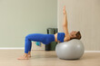 © zhagunov_a - Fit woman exercising on stability ball in blue activewear