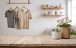 © Aken - Wooden tabletop, clothes, and plants.  Blurred background of a room