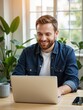 © Angelo - Working professional smiling at laptop in modern home office indoor environment natural light focused on tasks