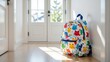 © Julia - Backpack leaning on hallway wall, colorful with cat pattern, hint of greenery outside. Concept of backpack leaning on hallway wall for stylish storage solution.