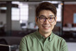 © wavebreak3 - Asian man in glasses smiling confidently in modern office environment