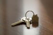 © Volodymyr Hankevych - Keys with house keychain on a wooden surface, symbolizing home ownership.