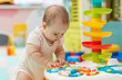 © Olha Tsiplyar - Baby exploring sensory toy table for development learning