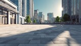 A wide, empty urban plaza with modern buildings around, clean pavement, clear sky, minimalistic style, natural lighting, no people, realistic shadows, perfect for background use, high quality