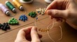 © Sumedani - Delicate Hands Crafting a Bead Necklace with Needle and Colorful Beads