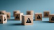 © Sutasinee - a wooden cube with a warning sign icon, An Exclamation Mark icon, on a blue background, Notice icon symbol, alert safety danger caution,notification error, and a maintenance concept.