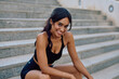 © we.bond.creations - Happy fitness model taking a break on concrete stairs, enjoying her healthy lifestyle and urban workout routine