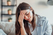 © Daniel - Unhappy young woman at home feeling sick and headache, girl touching her face feeling fatigue and exhausted. Girl with discomfort on the sofa, bad menstruation synths
