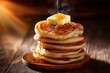 © Nasr - Golden stack of pancakes with butter and maple syrup on a wooden table