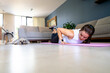 © Fabian Vargas - Woman exercising in her living room with her pets in workout clothes on a sunny day