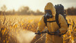© tojirapong - A person in protective gear spraying crops in a field, highlighting agricultural practices and environmental safety.