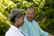 © wavebreak3 - In park, African American senior couple talking surrounded by lush greenery