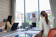 © Wanchai - Businessmen and women discussing contract terms with determination.