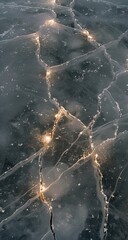  A high-angle close-up captures a network of cracks in a sheet of translucent ice, illuminated by warm light from beneath, creating a captivating interplay of light and shadow