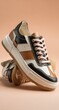 © Hardian - A pair of low-top sneakers in black, white, and tan leather, with a chunky sole and blush pink laces, are stylishly stacked against a muted background