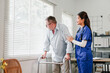 © PRIME STOCK LAB - Elderly man with walker supported by female nurse in home care, gentle encouragement and warm interaction