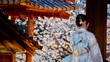 © CP Studios - Closeup of a women in a Japanese Kimono with temple and cherry blossoms in the background