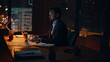 © stockbusters - Man manager working late at night office. Serious businessman typing laptop