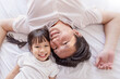 © paulaphoto - Portrait of joyful father young daughter lying close together on a bed, sharing a happy moment at home. Love father’s day