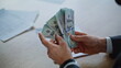 © stockbusters - Closeup hands counting money in luxury office. Businessman delivering dollars