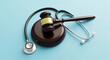 © Mehboob - Medical malpractice concept showing a gavel and stethoscope on a light blue background representing legal and healthcare issues