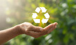 © abdul studio - Holding a brilliant recycling symbol for sustainable living in nature