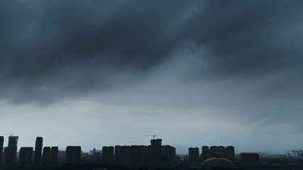 Wall Mural - Time lapse of dark clouds over a city