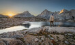 © RooM The Agency - Rear view of a man standing on a rock in front of Grinnell lake at dawn looking at the Sierra Nevada Mountains, Sierra National Forest, California, USA