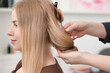 © New Africa - Professional hairstylist working with client in salon, closeup