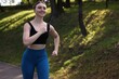 © New Africa - Smiling woman in sportswear running in park. Space for text