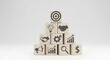 © adobe - Business growth strategy concept depicted with icons on stacked wooden blocks forming a pyramid structure with target goal.