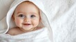 © afridwi - Smiling baby in white towel softness and comfort