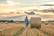 © shymar27 - Portrait of a young beautiful dark-haired girl in a summer dress in a village field among bales of straw.