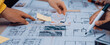 © InfiniteFlow - Hands engage in collaborative brainstorming over architectural plans and sketches, showcasing teamwork and creativity in a dynamic workspace filled with notes and drawings. SACTR