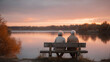© SolaruS - Elderly couple sitting on a bench enjoying a beautiful sunset over a tranquil lake. Represents love, companionship, retirement, and peaceful moments. Ideal for health, travel, and lifestyle content.