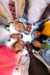 © Xavier Lorenzo - Smiling portrait of young college student friends joining faces in circle looking at camera. Youth community and diversity concept