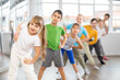 © JackF - Happy smiling preteen dancers practicing dance routine with female choreographer in modern studio