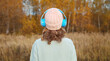 © rohappy - Inspired young woman enjoying listening to music in headphones outdoors in autumn forest