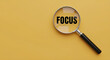 © Henhen - Magnifying glass focusing on the word 'FOCUS' on a yellow background.