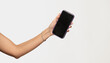 © serhii - female hand holding showing smartphone with blank dark screen on white background
