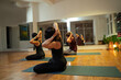 © phoenix021 - Three people man and woman doing arms and shoulder stretches on yoga class