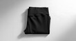 © ImIm - Top view of folded black sport leggings on a simple white surface. Minimalist activewear and comfortable fitness apparel concept for women